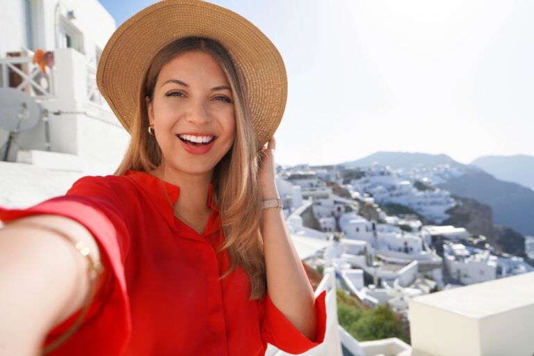 Woman in a red dress on vacation showing off dental implants